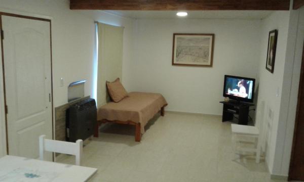 sala de estar con sofá y TV en Tu Casa en Villa General Belgrano Calamuchita Córdoba en Villa General Belgrano