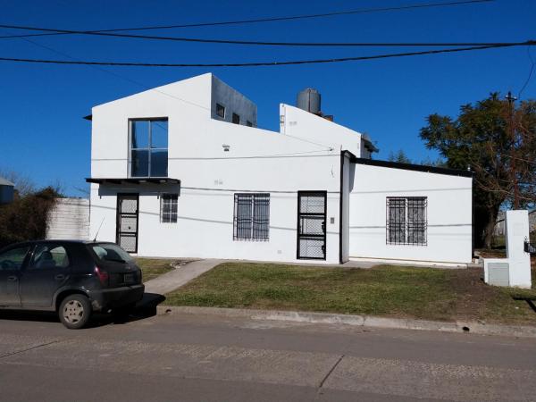 una casa blanca con un coche aparcado delante de ella en Casa En Gualeguaychu en Gualeguaychú