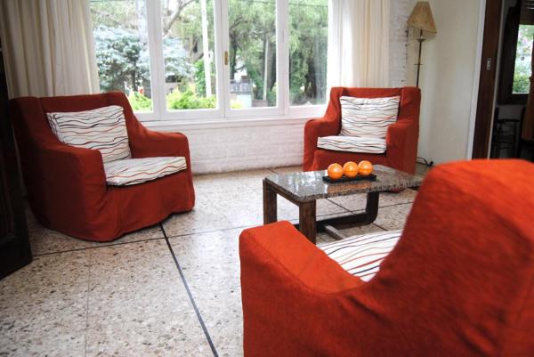 dos sillas rojas y una mesa en un salón del Hotel Norte de Villa Gesell