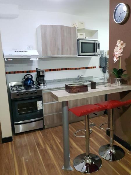 cocina con fogones y barra con mesa en Departamento zona céntrica (Caseros) en Salta