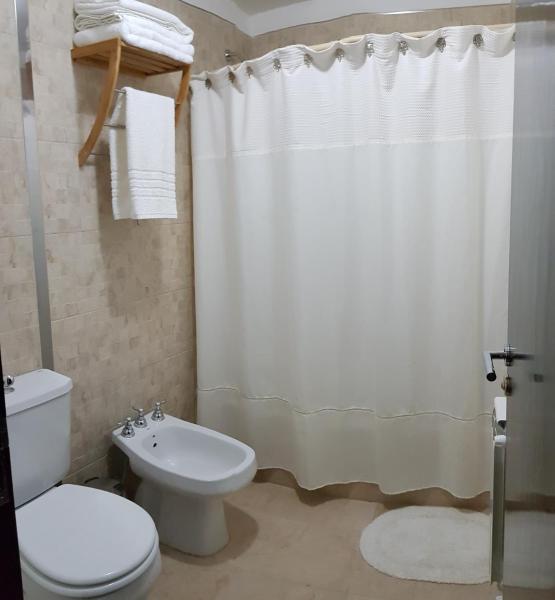 y baño con aseo y cortina de ducha. en Departamento zona céntrica (Caseros) en Salta