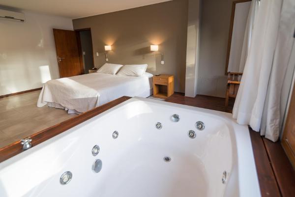 bañera en una habitación de hotel con cama en Rincon del Duende Resort y Spa de Mar, en Mar de las Pampas