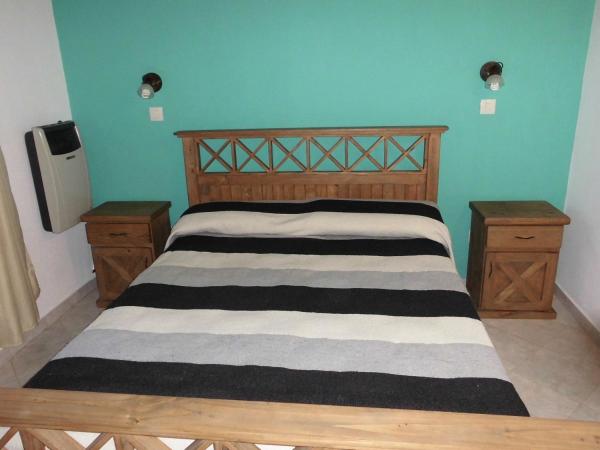 un dormitorio con cama de madera con pared azul en Pineta 4 y 7 de Villa Gesell