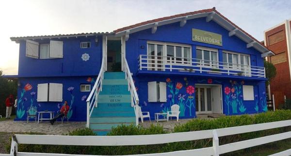 una casa azul con flores pintadas en ella en Hosteria Belvedere en Pinamar