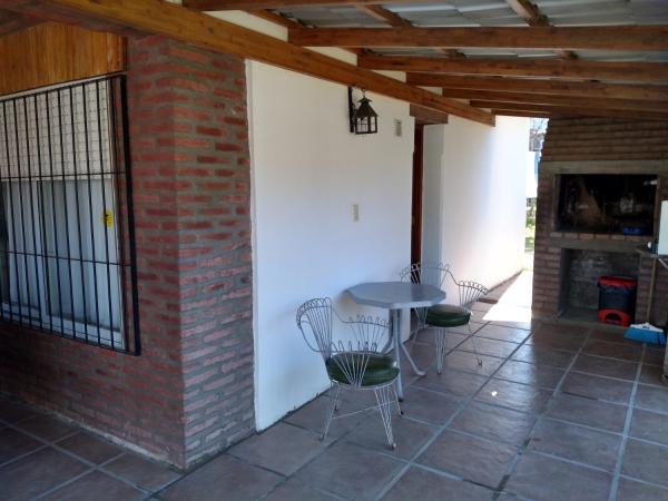patio con mesa, sillas y pared de ladrillo en Departamento Loma Hermosa, en Santa Rosa de Calamuchita