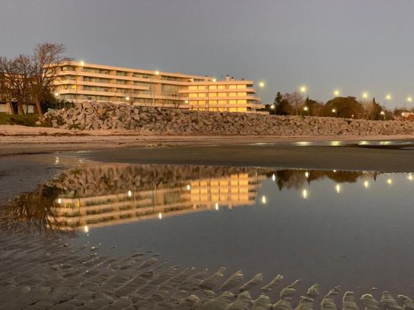 un reflejo de un edificio en un cuerpo de agua en Dos Orillas Monoambiente 412, en Colonia del Sacramento