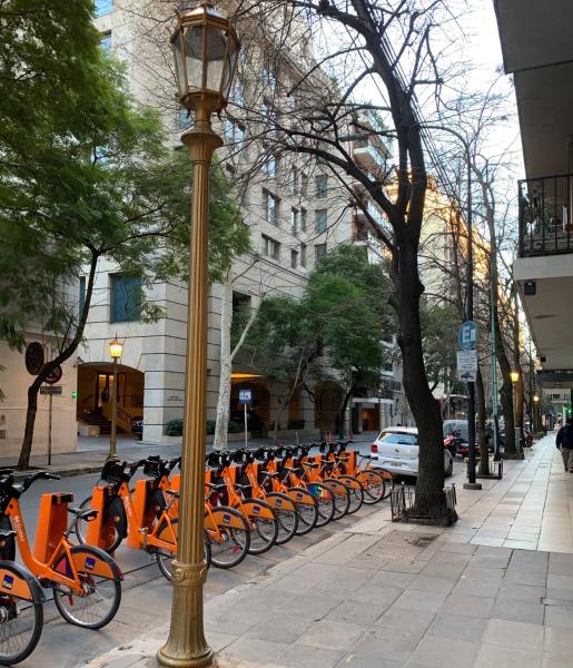 Una fila de motos naranjas estacionadas en una calle de la ciudad en Cozy studio in the heart of Recoleta en Buenos Aires