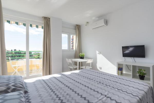 Habitación blanca con cama y balcón. en LU&CIA CANDADO BEACH RELAX, en Málaga
