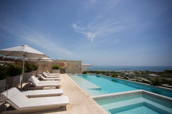 una piscina con tumbonas y sombrilla en Exclusive apartment- Rooftop pool -near the beach, en Cancún