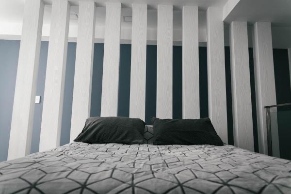 una cama en una habitación con una colcha blanca en Infinity Plaza PB Cálido departamento en el Centro de Ushuaia en Ushuaia