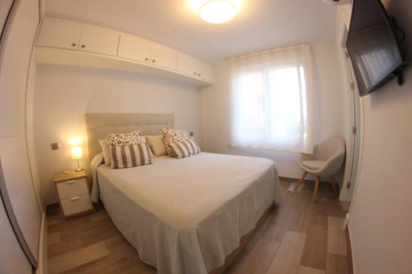 1 dormitorio con cama, ventana y TV en Paya Bella 2-1D, en Estepona