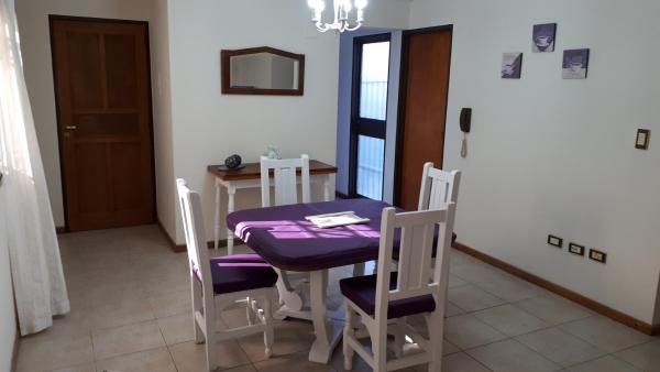 comedor con mesa y sillas de color púrpura en Departamento a 100mts de los Portones del Parque en Mendoza