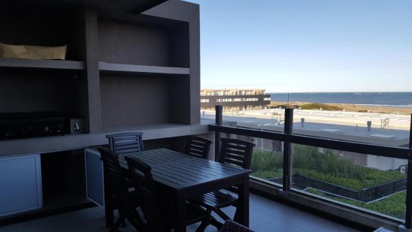balcón con mesa y sillas y vistas a la playa en Linda Bay Dúplex 221 en Mar de las Pampas