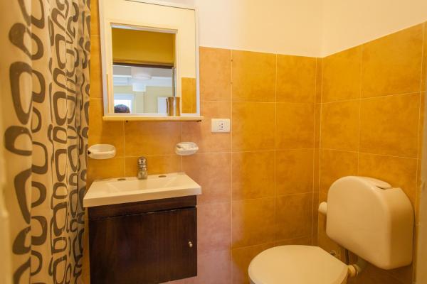 y baño con aseo, lavabo y espejo. en Dos Mareas Apart - Piscina Climatizada Cubierta en Ostende