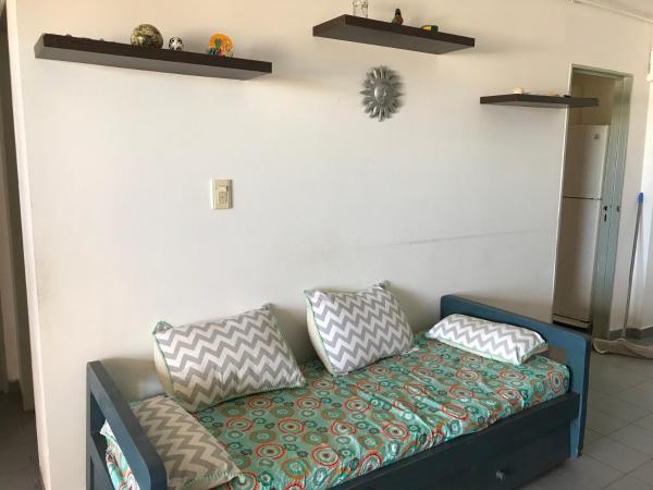 un sofá con almohadas en una habitación en el Departamento Libra XX ¡Ante el mar!  Super promo findas!!  en Villa Gesell