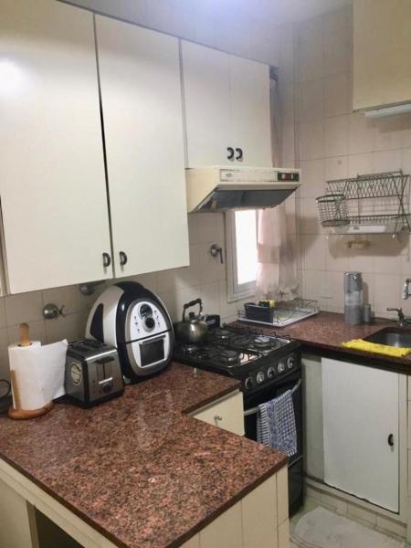 cocina con armarios blancos y encimera con microondas en Cómodo y equipado departamento en calle Paraguay, zona Teatro Colón en Buenos Aires