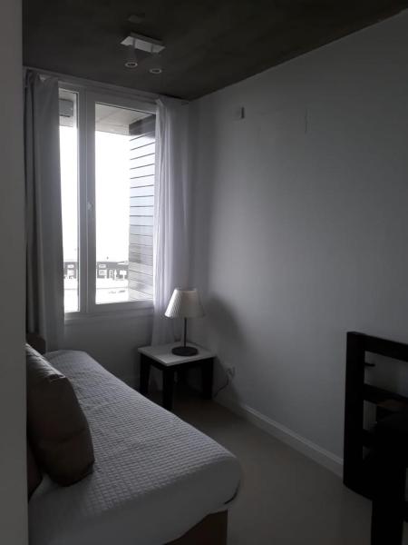 1 dormitorio con 1 cama y ventana con luz en Linda Bay Dúplex 221 en Mar de las Pampas