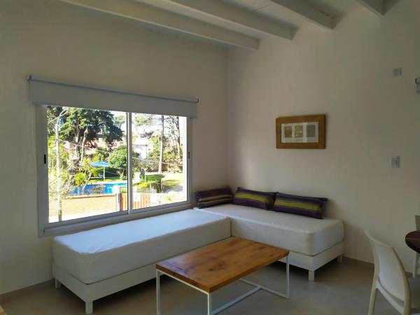 1 dormitorio con cama blanca y ventana a Departamentos La Esquina en Villa Gesell