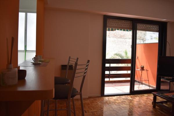 una cocina con mesa y sillas y una puerta corredera de cristal en Cálido, luminoso & excelente ubicación BA en Buenos Aires