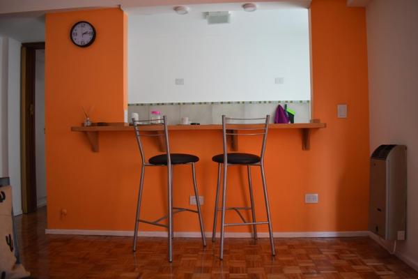 2 taburetes en una habitación con una pared naranja en Cálido, luminoso & excelente ubicación BA en Buenos Aires