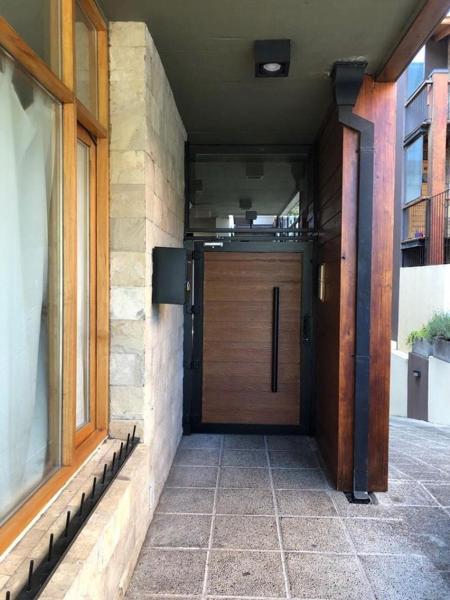 una puerta delantera de una casa con puerta de madera en Moderno Departamento Céntrico en San Martín de los Andes - Habitatsma en San Martín de los Andes