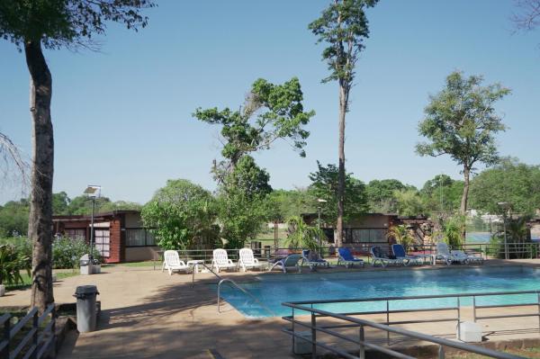 una piscina en un complejo con tumbonas y una piscina en Gran Hotel Tourbillon & Lodge en Puerto Iguazú