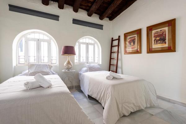 2 camas en una habitación con 2 ventanas en HSH Select Casa Pilatos, en Sevilla