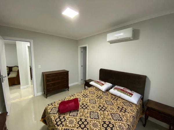 1 dormitorio con 1 cama con 2 almohadas en Edifício Florenza, en Bombinhas
