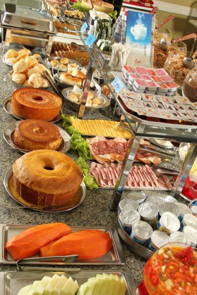 a buffet filled with lots of different types of food at Trevi Hotel e Business in Curitiba