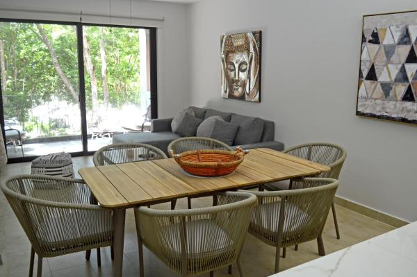 sala de estar con mesa de madera y sillas en Departamento perfecto, en Playa del Carmen