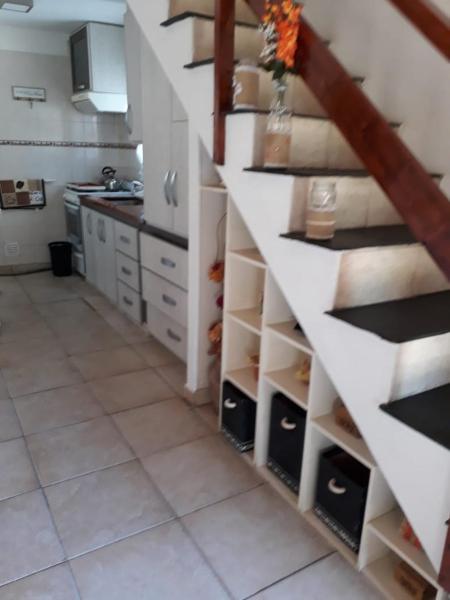 una cocina con una escalera con estantes en una cocina en Chalet en Villa Gesell en Villa Gesell