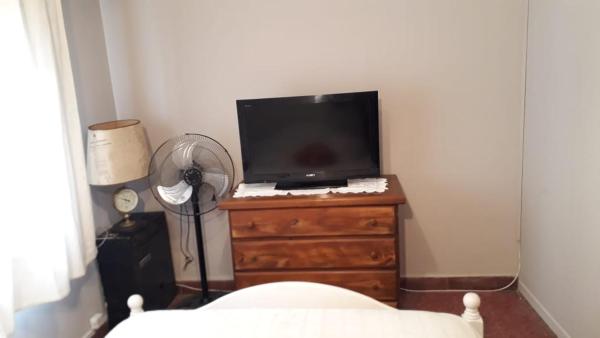 1 dormitorio con TV en un tocador con ventilador en el Departamento a media cuadra del mar Edificio "Mont Blanc" en Villa Gesell
