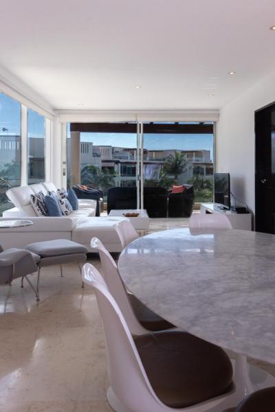 sala de estar con muebles blancos, mesa y sillas en Elements Penthouse 6, en Playa del Carmen