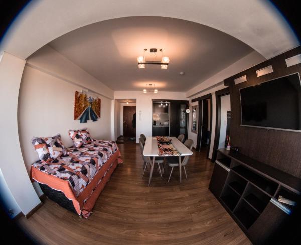 un dormitorio con cama y un comedor en Amanecer Fueguino II en Ushuaia