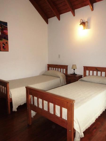 1 dormitorio con 2 camas y una lámpara en la pared en 4 SOLES en Villa Gesell