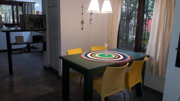 mesa de comedor con sillas amarillas y mesa verde en La Ventarrón Planta Baja en Mar de las Pampas
