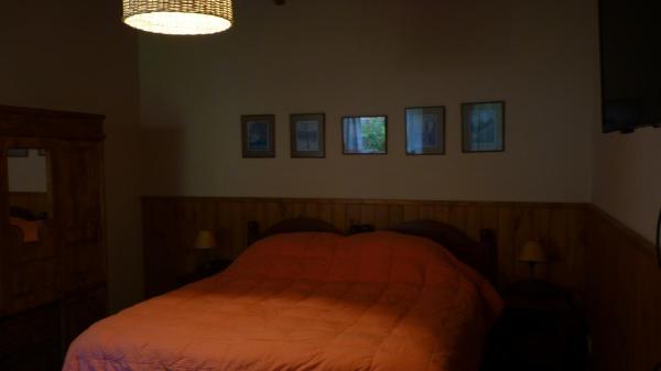 1 dormitorio con 1 cama y cuadros en la pared en Los notros 190 en San Martín de los Andes