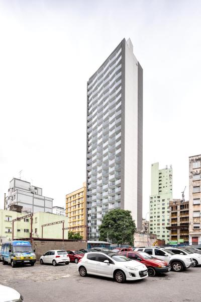 un estacionamiento con autos estacionados frente a un edificio alto en 360 Suítes Sé - Apartamentos mobiliados, en São Paulo