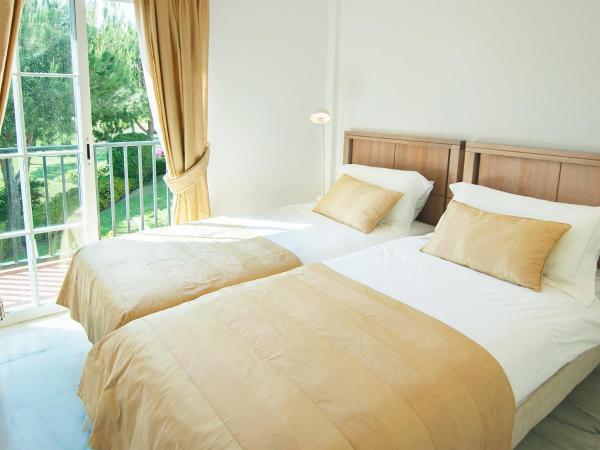 2 camas en una habitación con ventana grande en Holiday Home Los lomos de Cabopino, en Marbella