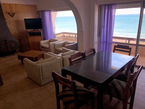 una sala de estar con mesa y sillas y el océano en Solana Del Mar en Las Grutas
