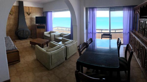 sala de estar con mesa y sala de estar con vistas al océano en Solana Del Mar en Las Grutas