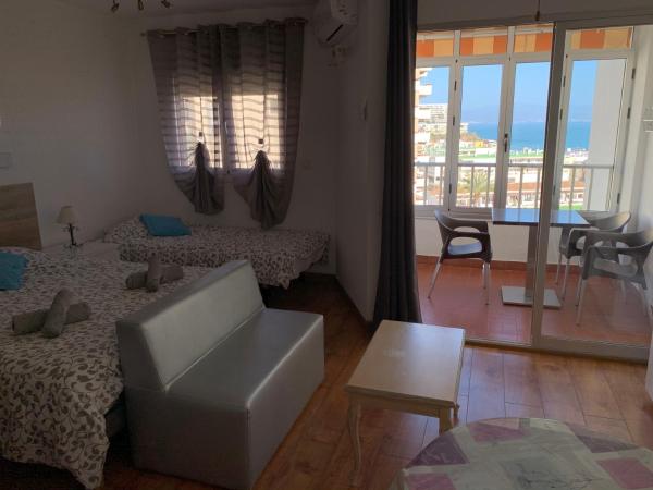 Habitación con 2 camas y salón con balcón.  en Palm Beach 8th - La Carihuela, en Torremolinos