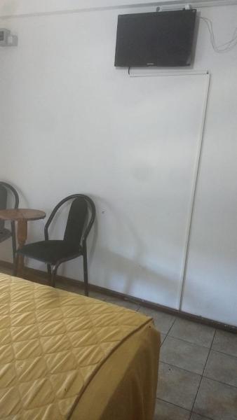 una habitación con dos sillas y una mesa y un televisor en el Hotel Las 40 de Villa Gesell