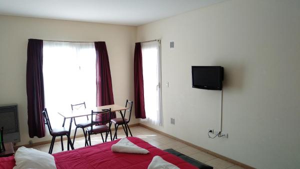 1 dormitorio con 1 cama y 1 mesa con sillas en Diez ApartHotel en Puerto Madryn