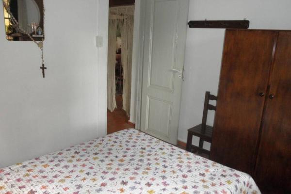 1 dormitorio con 1 cama y puerta de madera en Chalet Don Vicente en Villa Gesell