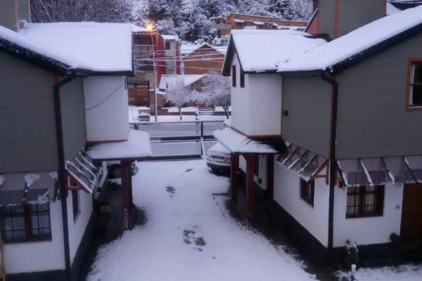 un grupo de casas con nieve. en Los Cerezos en San Martín de los Andes