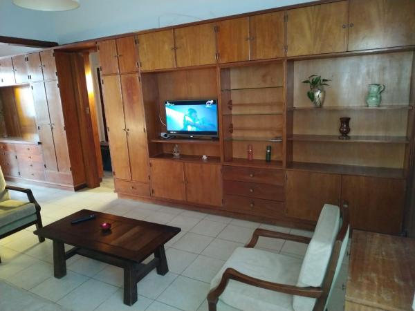 sala de estar con TV y mesa en La Casa de la Oma en Tandil