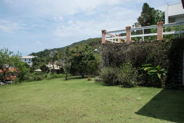 a yard with a hedge and a building at Casa Vista Mar Deslumbrante com Piscina CAN5 in Florianópolis