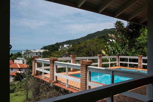 a view from the balcony of a house with a swimming pool at Casa Vista Mar Deslumbrante com Piscina CAN5 in Florianópolis