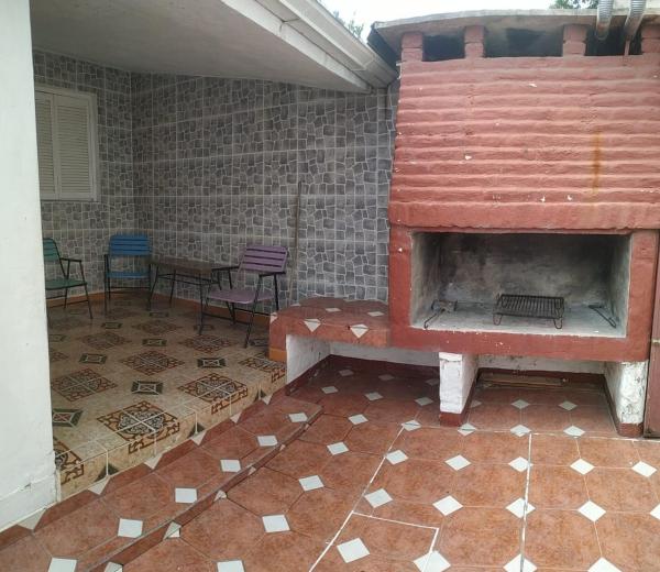 chimenea al aire libre en una habitación con suelo de baldosa en la Herradura Dptos, en Santa Rosa de Calamuchita